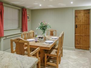 a dining room with a wooden table and chairs at Lavender Cottage - Ukc9687 in Thorndon