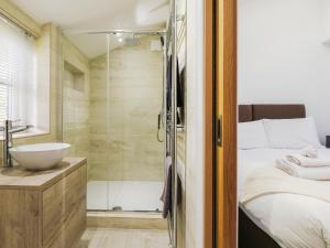a bathroom with a shower and a bed and a sink at Lavender Cottage - Ukc9687 in Thorndon +6 photos