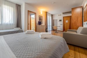 a hotel room with a bed and a couch at Hotel Rubicone in Savignano sul Rubicone
