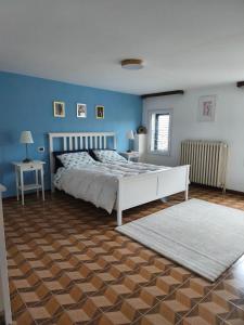 a bedroom with a white bed and blue walls at Civico 18 in Caposotto