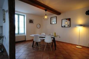 a dining room with a table and white chairs at La Maison Rose in Mhère