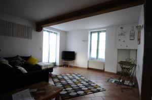 a living room with a couch and a television at La Maison Rose in Mhère