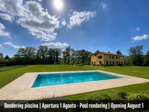 a swimming pool in a field with a house at Agriturismo Villa Tadina in Gualdo Tadino