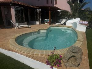 a swimming pool in a yard with a house at Casa Vacanza Li Menduli San Teodoro in San Teodoro