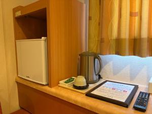 un bancone con una macchina per il caffè e un telefono sopra di Hotel Ikeda a Nagasaki Altre 13 foto