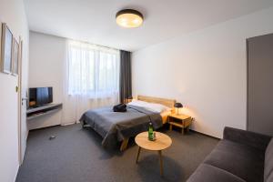 a hotel room with a bed and a couch at Vila Matliare in Tatranská Lomnica