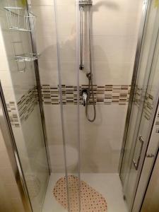una doccia con una porta in vetro in un bagno di Bellezia a Torino
