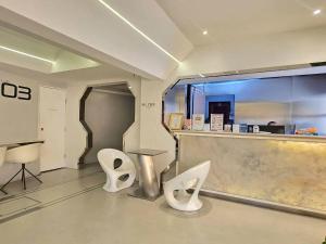 a lobby with a counter and two white chairs at Big Tree Old Town Hotel in Chiang Mai