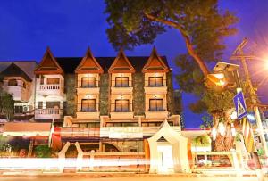 a large building with lights on in front of it at Big Tree Old Town Hotel in Chiang Mai