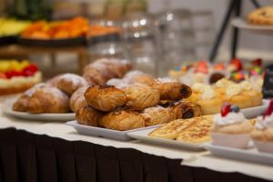 a table filled with different types of pastries on plates at Hotel Bellini in Riccione +48 photos