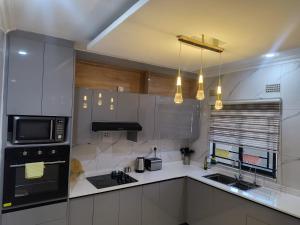 a kitchen with white cabinets and a black microwave at Gabstel Apartments in Kitwe