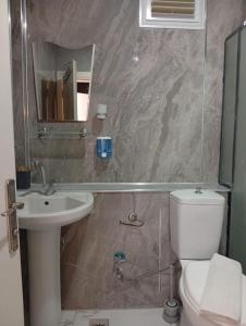 a bathroom with a toilet and a sink and a mirror at Barış Otel in Didim