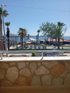 a park with a fence and tables and palm trees at Barış Otel in Didim