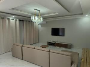 a living room with a couch and a flat screen tv at Gabstel Apartments in Kitwe