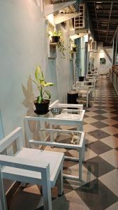 a row of white tables and chairs in a room at Hotel Paris Santika in Rawara