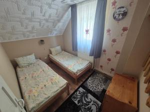 a small room with two beds and a window at Silentium Clavem Domus II. in Satu Mare