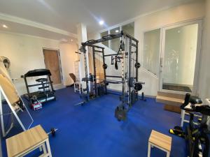 a gym with a blue floor and several tread machines at Hotel Paris Santika in Rawara