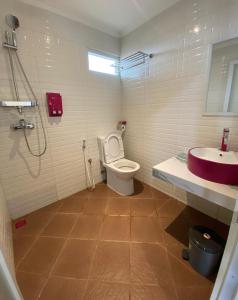 a bathroom with a toilet and a sink at Hotel Paris Santika in Rawara +2 photos