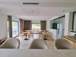 a living room with chairs and tables and a kitchen at Marisel Escape Chalet in Mărişel