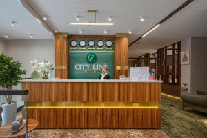 a woman standing at a city line hotel lobby at City Line HOTEL in Astana
