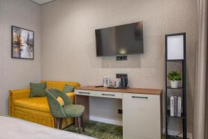 a hotel room with a desk and a television on the wall at City Line HOTEL in Astana