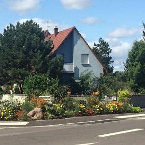 uma casa ao lado de uma estrada com flores em B&B chez Didier et Catherine em Ittenheim