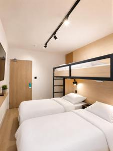 a hotel room with three beds with white sheets at Kyriad ECO - Tours Nord in Tours