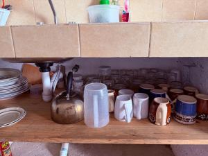 a shelf with a bunch of cups on it at Cabañas D Güereo By GEstores in Mineral del Chico +56 photos