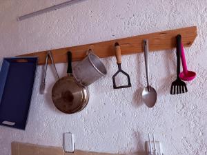 a bunch of kitchen utensils hanging on a wall at Cabañas D Güereo By GEstores in Mineral del Chico
