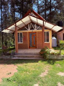 a small house with a porch and a door at Cabañas D Güereo By GEstores in Mineral del Chico