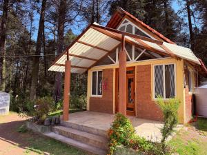 a small house with a porch and stairs to it at Cabañas D Güereo By GEstores in Mineral del Chico