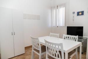 a white dining room with a white table and chairs at Appartamento Sunny by ThePuglia in Torre Lapillo