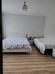 a bedroom with two beds and a wooden floor at Sun ray in Ch'ik'unet'i