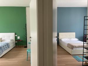 two beds in a room with green walls at Chagall Pascoli 10 in Asti