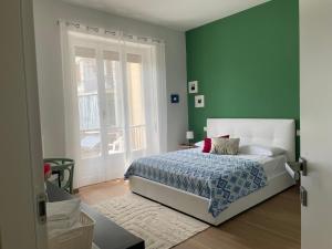 a bedroom with a bed and a green wall at Chagall Pascoli 10 in Asti +4 photos