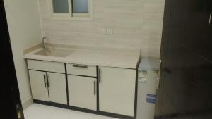 a kitchen with a sink and a refrigerator at فرس ابها - شقق مفروشه in Abha