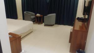 a hotel room with a bed and two chairs at فرس ابها - شقق مفروشه in Abha