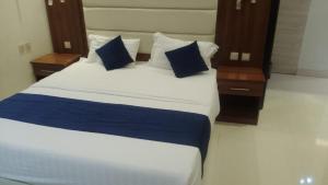 a large bed with blue and white sheets and pillows at فرس ابها - شقق مفروشه in Abha