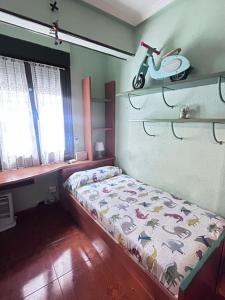 a small bedroom with a bed and a scooter on the wall at Centrico tu hogar en Bilbao in Barakaldo