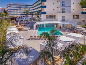an outdoor swimming pool with lounge chairs and a hotel at GHT Aquarium & Spa in Lloret de Mar