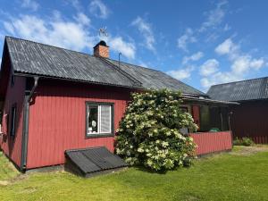 a red house with a dog in a window at Lasmarmas in Älvkarleby