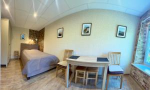 a bedroom with a bed and a table and chairs at Butas Prie Kaštono in Nida