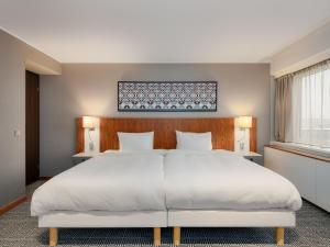 a bedroom with a large white bed and a window at Radisson Blu Hotel Olümpia in Tallinn +73 photos
