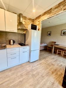 a kitchen with a white refrigerator and a table at Butas Prie Kaštono in Nida