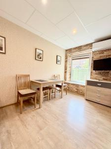 a dining room with a table and chairs and a tv at Butas Prie Kaštono in Nida