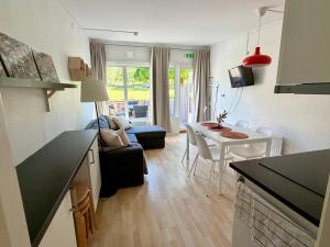 a kitchen and living room with a couch and a table at Hällestrand Semesterby R19 in Strömstad