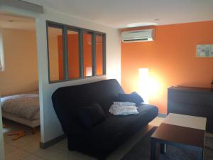 a living room with a couch and a bed at B&B chez Didier et Catherine in Ittenheim