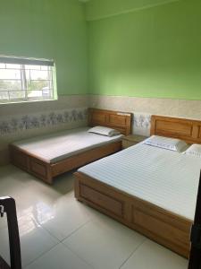 two beds in a room with green walls at khách sạn gia bình in Xóm Miếu