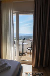 a bedroom with a view of a balcony with a table at Villa Mefaja in Krujë