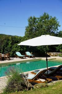 a white umbrella and chairs next to a swimming pool at Mas De Garrigue - Chambres d'hôtes in Calvignac +31 photos